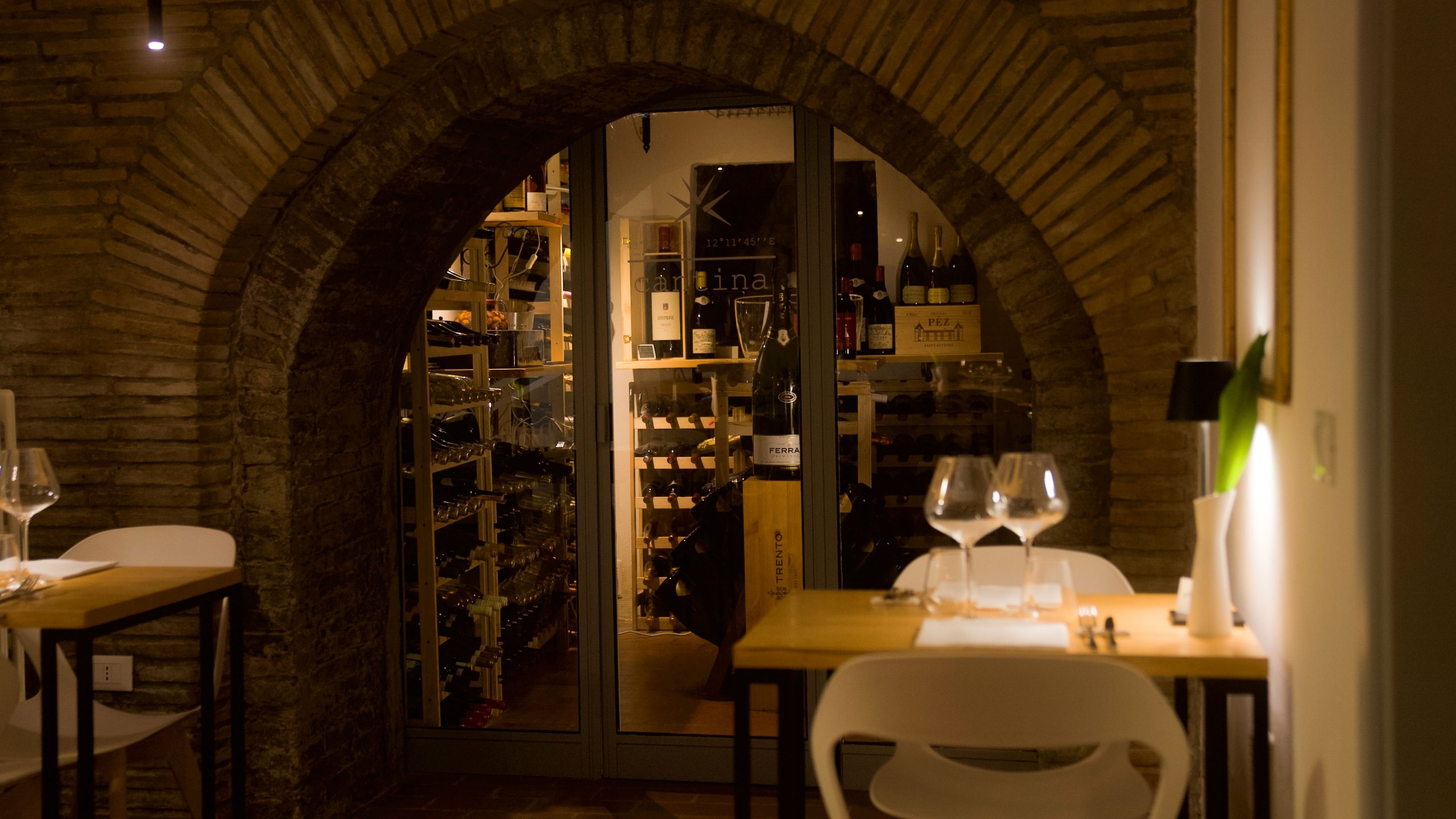 La cantina di Cantina Veggiani, con bottiglie fra pareti e volte in mattoni