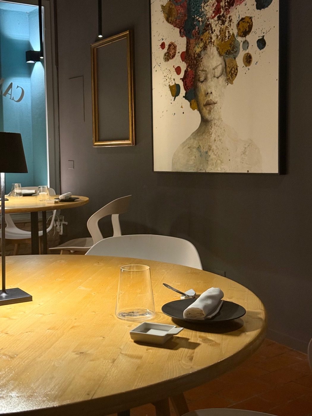 Un tavolo della sala di Cantina Veggiani accanto al quadro